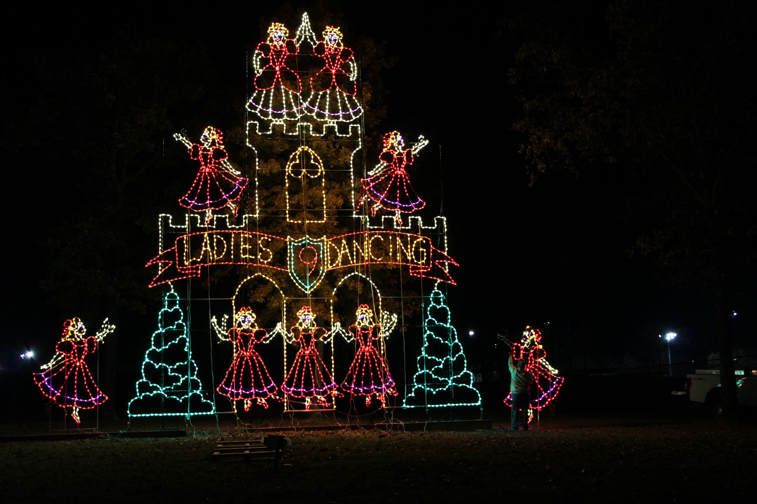 Image of light display for Trail of Lights depicting the 9th Day of Christmas with 9 Ladies Dancing